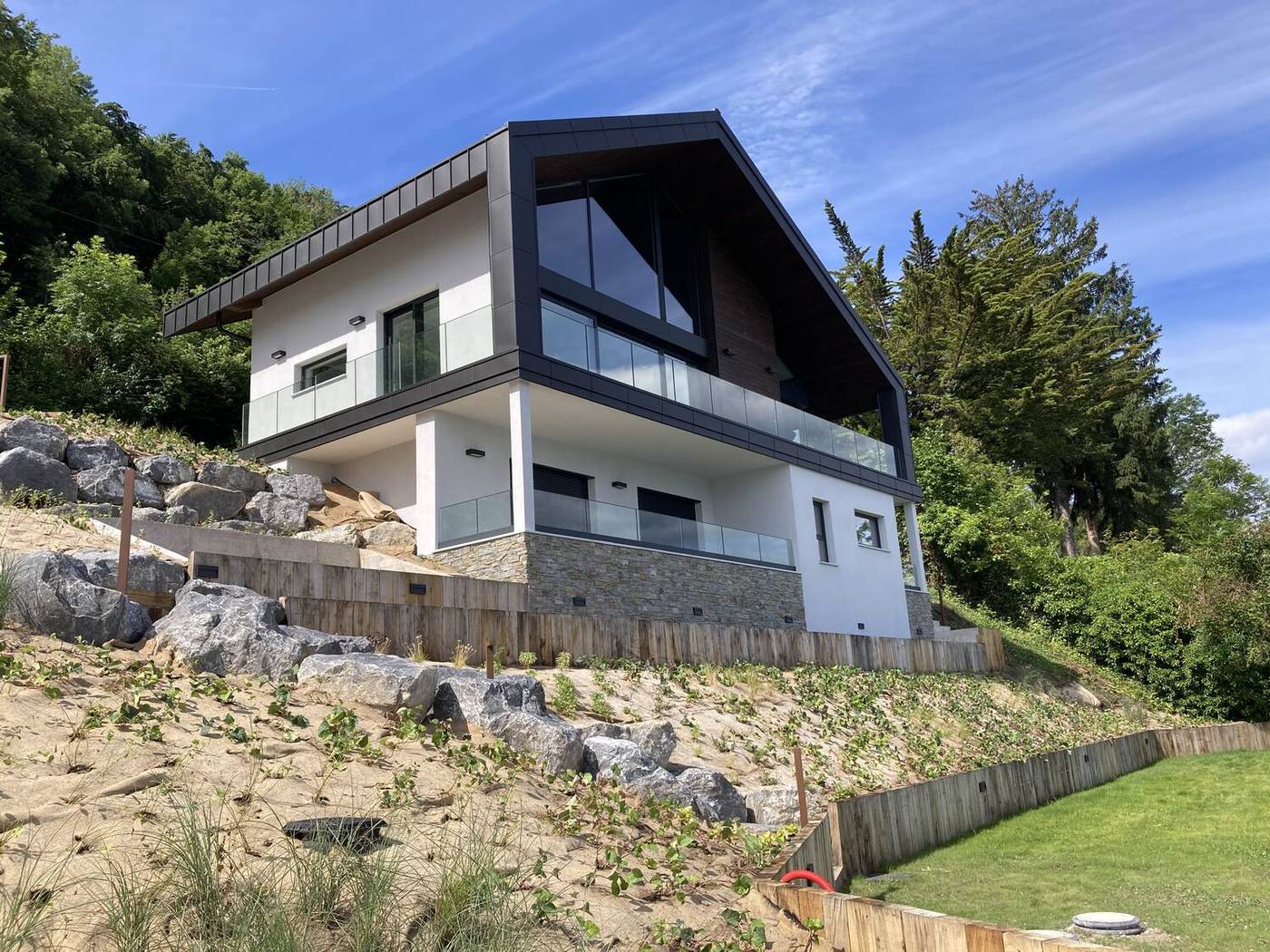 La maison et le jardin depuis le lac, façade sud entièrement vitrée